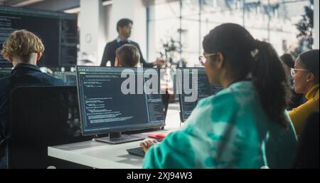 Portrait of a Teacher Giving Lesson to Diverse Multiethnic Group of Female and Male Students. Class Learning About Computer Science and Software Development. Lecturer Shares Knowledge with Scholars Stock Photo