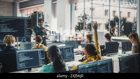 Portrait of a Young Inspired Black Female Student Studying in College with Diverse Classmates. African Girl Asking Teacher a Question. Girl Using Computer to Acquire IT Skills in Class Stock Photo