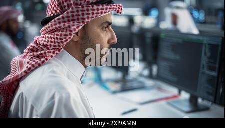 Portrait of a Middle Eastern Engineer Working on Desktop Computer in a Technological Office Environment. Arab Software Developer Researching New Ideas to Problem Solve a Technical Assignment Stock Photo