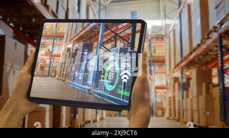 Futuristic Technology Warehouse: Worker Doing Inventory And Using Augmented Reality Application On Tablet. Digitalization Process Analyzes Products with Delivery Infographics in Distribution Center Stock Photo