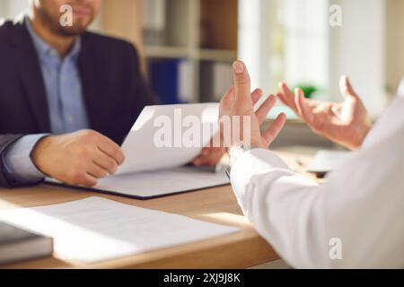 Two company employees sitting in office looking through financial documents. Stock Photo