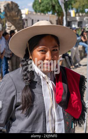 A female gaucho in traditional red Salteño poncho rides at the head of ...