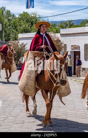 A female gaucho wearing a traditional red Salteño poncho in a parade in ...