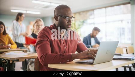 Adult Education Center: African Student Learning in Classroom, Using Laptop to Write Down Notes. Group of People Taking a Workshop on Improving Professional Work Skills Stock Photo