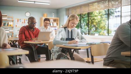 Grown-Up Men and Women Getting Specialty Knowledge on an Evening Course in College. Adult Class Writing Down Notes in Notebook and Using Laptop Computers, Acquiring New Useful Academic Skills. Stock Photo