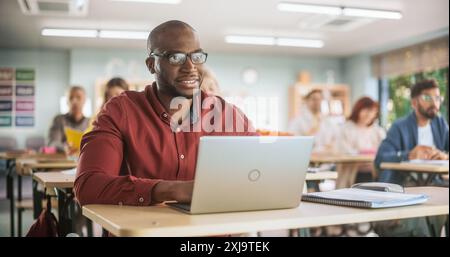 Adult Education Center: African Student Learning in Classroom And Smiling, Using Laptop to Write Down Notes. Group of People Taking a Workshop on Improving Their Professional Work Skills. Stock Photo