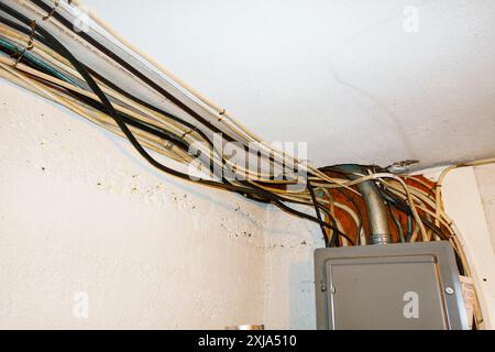 Exposed home electrical wires in basement. Stock Photo