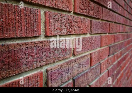 Close-up of an old clay red brick wall, laid in a running bond pattern with mortar horizontally, brickwork pattern. Stock Photo