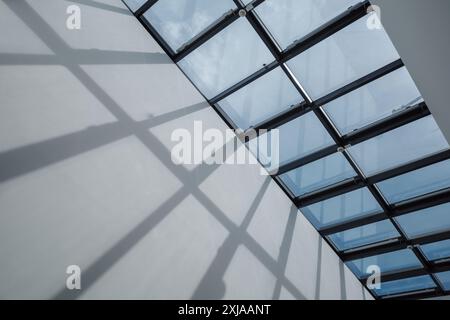 modern skylight composed of a grid of glass panels set within a sleek, metal frame. Stock Photo