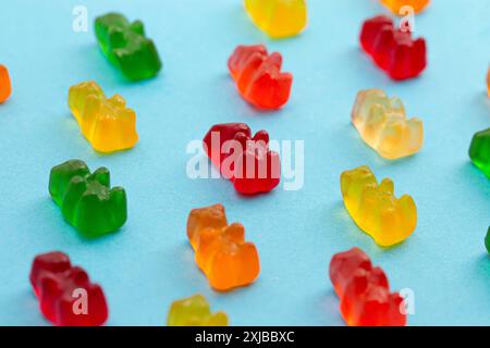 Rainbow Colored Bear Shaped Gummy Candies Isolated on a Blue Background Stock Photo