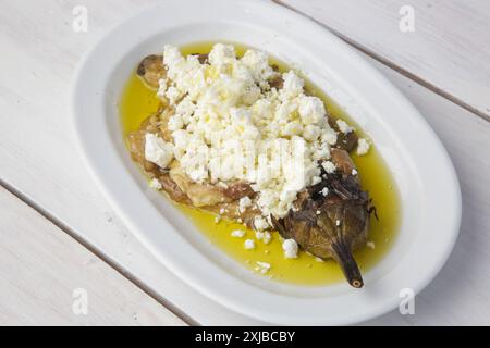 Mediterranean cuisine, roasted eggplant stuffed with feta cheese in olive oil Stock Photo