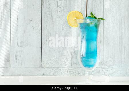 Glass of blue lagoon cocktail on wooden backgound Stock Photo