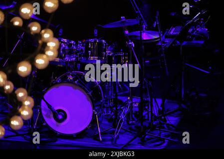 A drum set on the stage of a dimly lit live music venue before the show begins Stock Photo