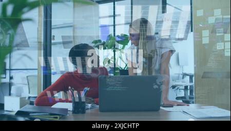 Image of graphs and globes over diverse female coworkers discussing reports on desk in office Stock Photo