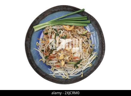 Traditional Fried Thai Noodles (Pad Thai) with Egg, Fried tofu, Dried shrimp, Bean sprouts, Chives and Roasted peanuts on Ceramic plate isolated on wh Stock Photo