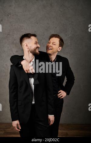 Two men in elegant suits share a loving gaze, reflecting deep affection for each other. Stock Photo