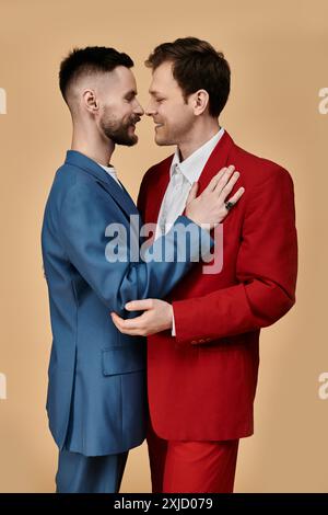 Two men in suits embrace, their love evident in their gaze. Stock Photo