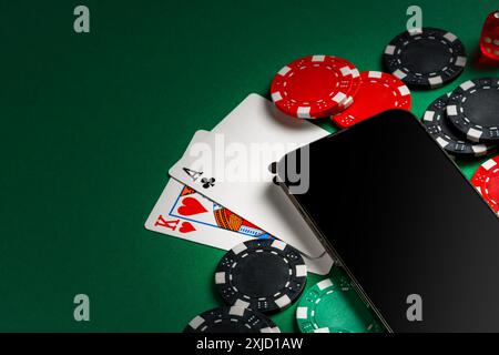 Smartphone With Playing Cards and Chips on a Green Felt Tabletop Stock Photo