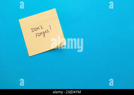 A simple yellow sticky note on blue, perfect for adding your reminder! Stock Photo