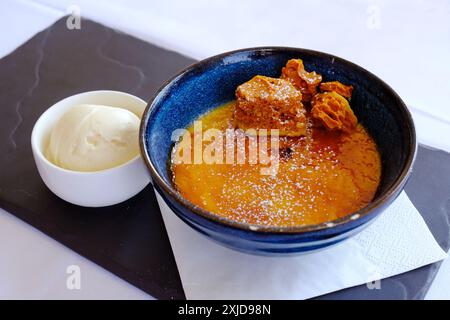 Chocolate creme brulee with a side dish of vanilla ice-cream - John Gollop Stock Photo