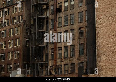 Steel fire escape staircase and rear windows exposed in the void space created after the demolition of a Midtown building on 5th Avenue, New York City Stock Photo