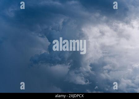 Dramatic view of dark storm clouds forming in the sky, indicating an impending storm with contrasting shades of blue and gray.  Stock Photo