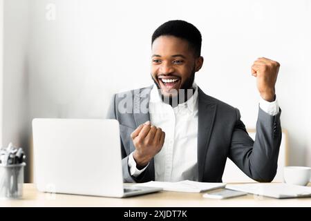 Excited Businessman Celebrating Success at Laptop Stock Photo