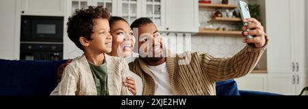 African American man taking selfie with loving family at home. Stock Photo