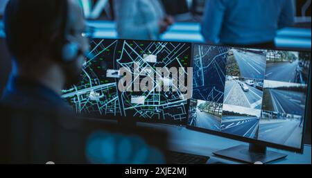 Multiethnic Specialist in a Dark High-Tech Monitoring Room, Concentrated on a Call and Computer Work. Technical Support Manager Using Headphones with Built-In Mic for Communication with Customers Stock Photo