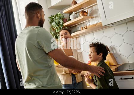 A man and woman spending time with their son in a warm kitchen setting. Stock Photo