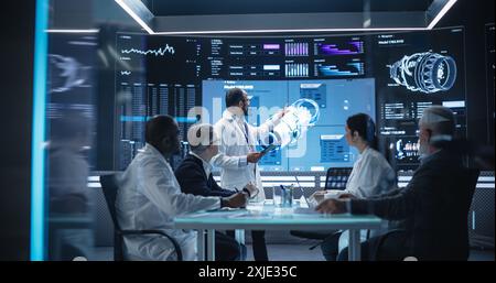 Team of Industrial Engineers Having a Meeting in a Research and Development Science Laboratory. Diverse Group of Professionals Discussing New Turbine Design on Big Digital Screen Stock Photo