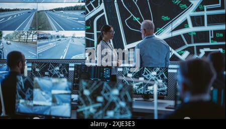 Advanced City Planning Monitoring Center with Diverse Male and Female Officers Analyzing CCTV Footage, Traffic Data and Road Situation on a Big Digital Screen. Team of Specialists Working in Office Stock Photo