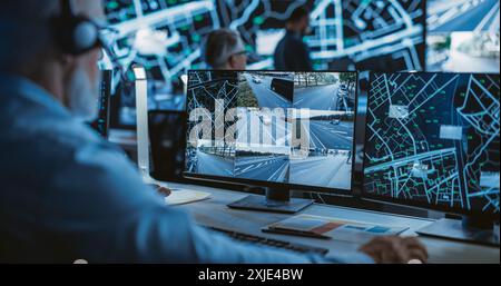Technical Customer Support Specialist is Talking on a Headset while Working on a Computer in a Call Center Control Room Filled Display Screens with Monitoring Software. Over the Shoulder Footage Stock Photo