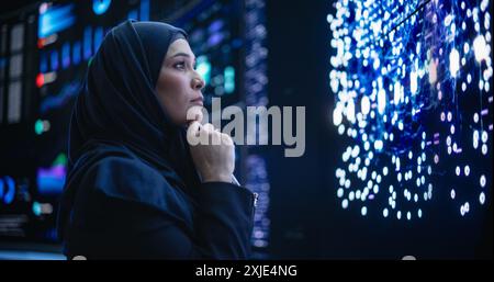 Portrait of a Thoughtful Middle Eastern Software Developer Working in Technological Corporate Office. Young Woman Testing Artificial Intelligence Algorithms for an Innovative Internet Project Stock Photo