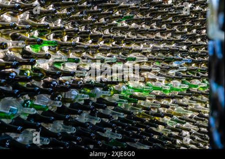 Wine bottles in a row on a stone wall.  Abstract decorative glass bottle backgroud pattern. Close-up Stock Photo