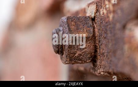 rusty bolt with nut. Anchor attachment to wall. Element of building construction. Stock Photo