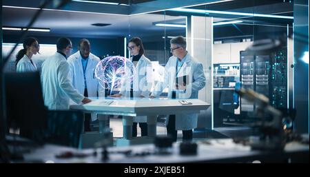 Diverse Group Of Neuroscientists Having A Meeting Around Futuristic Computer Hologram Of Human Brain In Laboratory. Researchers Looking at AI-Powered VFX Projection High-Tech Concept. Stock Photo