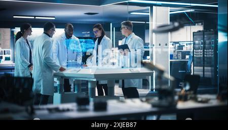 Diverse Team of Industrial Engineers Using Futuristic Hologram of Wind Turbine Prototype In Computer Powered Laboratory. Multiethnic Colleagues Looking VFX Projection. High Technology Concept. Stock Photo