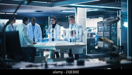 Diverse Team of Industrial Engineers Using Futuristic Hologram of Wind Turbine Prototype In Computer Powered Laboratory. Multiethnic Colleagues Looking VFX Projection. High Tech Concept. Stock Photo