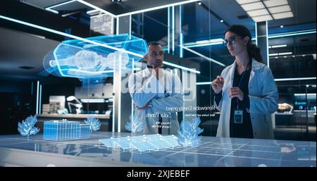 Male And Female Industrial Engineers Using Futuristic Technology Of Hologram of Wind Turbine Prototype In Computer Powered Laboratory. Multiethnic Colleagues Looking At High-Tech VFX Projection. Stock Photo