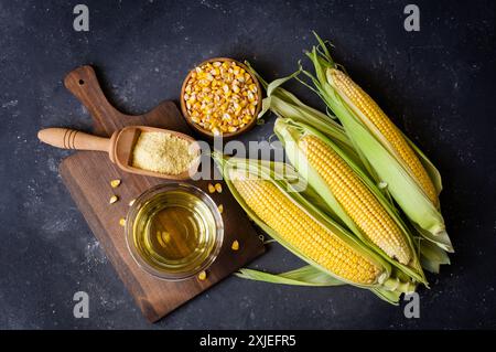 Corn oil and corn flour with fresh corncobs on rustic table, corn food ingredients concept Stock Photo
