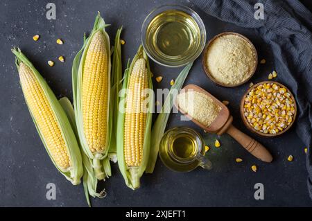 Corn oil and corn flour with fresh corncobs on rustic table, corn food ingredients concept Stock Photo