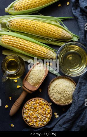 Corn oil and corn flour with fresh corncobs on rustic table, corn food ingredients concept Stock Photo