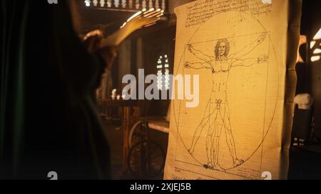 Medium Shot of the Drawing of the Vitruvian Man by Leonardo da Vinci Resting on an Easel in Renaissance Art Studio. Famous Piece Representing Science, Art, Health and Fitness. Scientist Studying it Stock Photo