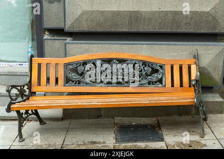 Tbilisi, Georgia - 20 JUNE, 2024: Wooden and cast iron bench on Rustaveli Avenue in Tbilisi. The georgian text Mtatsminda shows it was brought from th Stock Photo