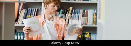 Man arranging papers in front of a bookshelf. Stock Photo