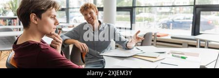 Two young male students deep in study at a library table. Stock Photo