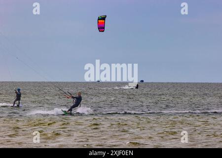 Frisco, Outer Banks, North Carolina, USA April 16, 2024:  Kiteboarders can be seen sailing across the sea water. Stock Photo