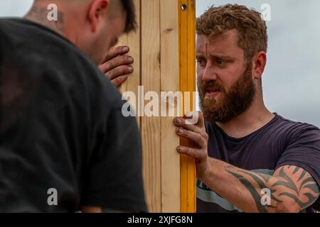 Construction workers working on assembling a new roof on a residential house Stock Photo