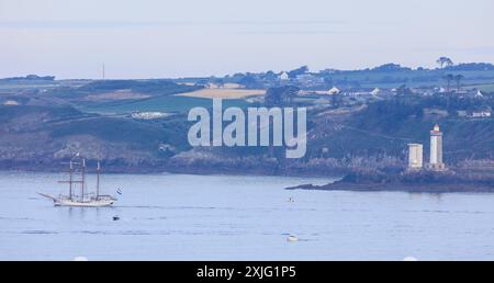 Dreimaster Loth Lorien vor dem Leuchtturm Phare du Petit Minou, La Grande Parade, Fahrt der Traditionssegler von Brest nach Douarnenez zuzm Abschluß der Fetes Maritimes 2024 in Brest, gesehen vom Fort des Capucins auf der Halbinsel Crozon nahe der Einfahrt in die Bucht Rade de Brest, Gemeinde Roscanvel, Departement Finistere Penn-ar-Bed, Region Bretagne Breizh, Frankreich *** Three-master Loth Lorien in front of the lighthouse Phare du Petit Minou, La Grande Parade, voyage of the traditional sailors from Brest to Douarnenez at the end of the Fetes Maritimes 2024 in Brest, seen from the Fort de Stock Photo